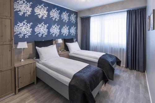 two beds in a hotel room with snowflakes on the wall at Best Western Leto Arena in Dal