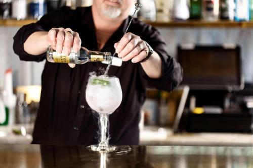 a man is pouring a drink into a glass at Best Western Hotel Baltic in Sundsvall