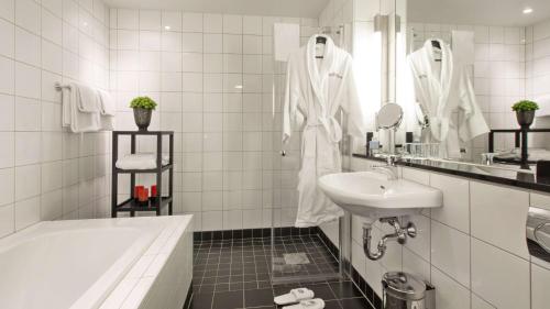 a white bathroom with a tub and a sink at Best Western Plus Time Hotel in Stockholm