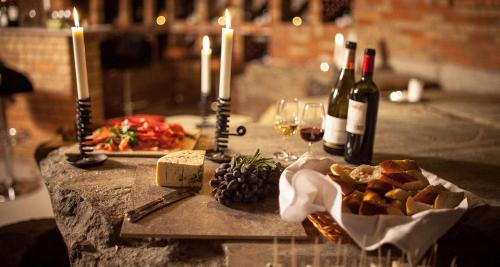 a table topped with candles and wine bottles and food at Best Western Gustaf Froding Hotel & Konferens in Karlstad