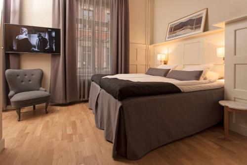 a bedroom with a large bed and a chair at Best Western Hotel Baltic in Sundsvall
