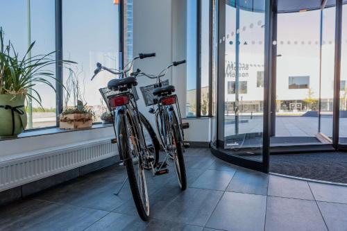 two bikes parked in a room with windows at Best Western Malmo Arena Hotel in Malmö