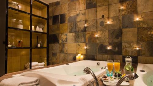 a bathroom with a tub and glasses of champagne at Best Western Hotel Herman Bang in Frederikshavn