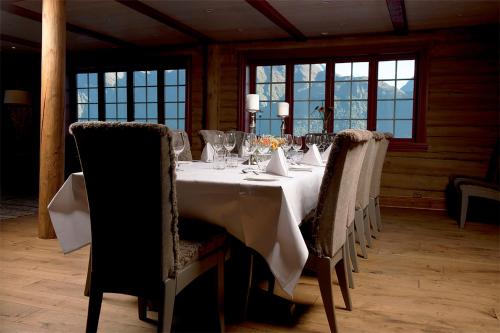 a dining room with a white table and chairs at Sagafjord Hotel - by Classic Norway Hotels in Sæbø