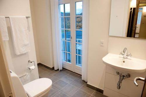 a bathroom with a sink and a toilet and a window at Gl Skovridergaard in Silkeborg