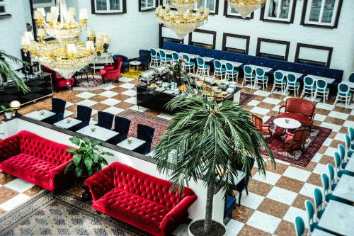 a room with red couches and tables and chairs at Best Western Hotel Bentleys in Stockholm