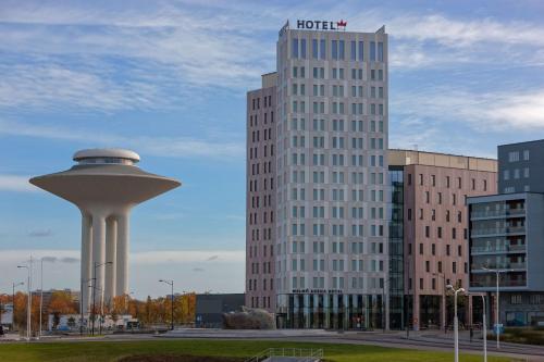 a hotel and a water tower in front of buildings at Best Western Malmo Arena Hotel in Malmö