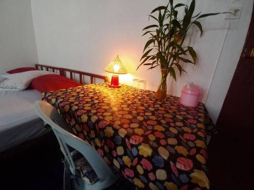 a table with a lamp in a room with a bed at Prasuri Guest House in Bangkok