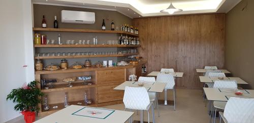 a restaurant with tables and chairs and a shelf with wine bottles at Stella Marina Agropoli in Agropoli