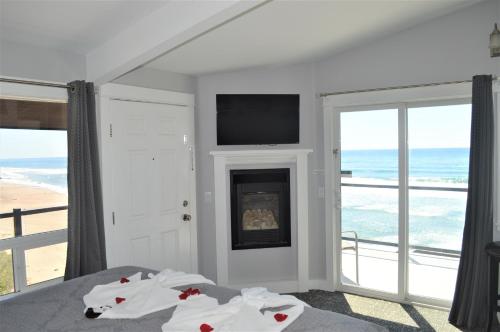 a bedroom with a bed with a fireplace and a television at Beachfront Manor Hotel in Lincoln City