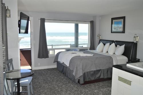 a hotel room with a bed and a view of the ocean at Beachfront Manor Hotel in Lincoln City