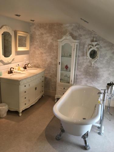 a bathroom with a tub and a sink at Lilly's Pad in Keelby