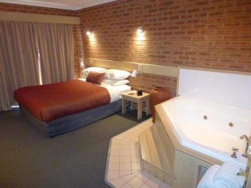 A bed or beds in a room at Colonial Motor Inn Bairnsdale Golden Chain Property