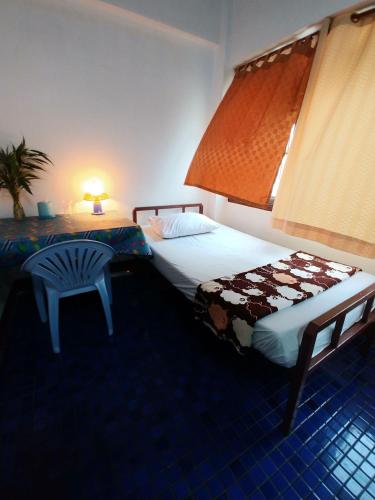 a hotel room with two beds and a table at Prasuri Guest House in Bangkok