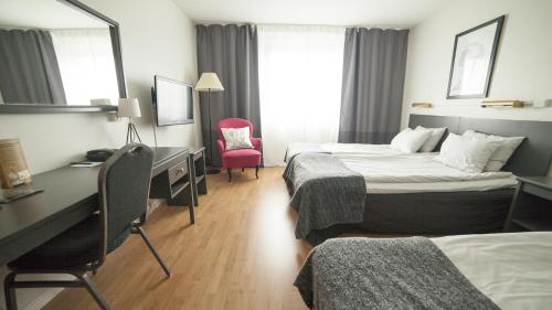 a hotel room with two beds and a desk at Best Western Gustaf Froding Hotel & Konferens in Karlstad