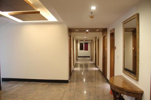 a hallway of an office building with a table and a mirror at Hotel Southern Grand in Vijayawāda