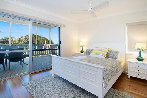 a bedroom with a bed and a balcony at Seascape - Lennox Head in Lennox Head