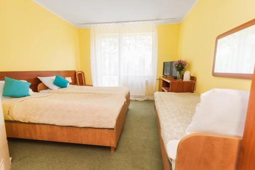 シャノジェンティにあるNadmorski Rajのベッド2台と窓が備わるホテルルームです。