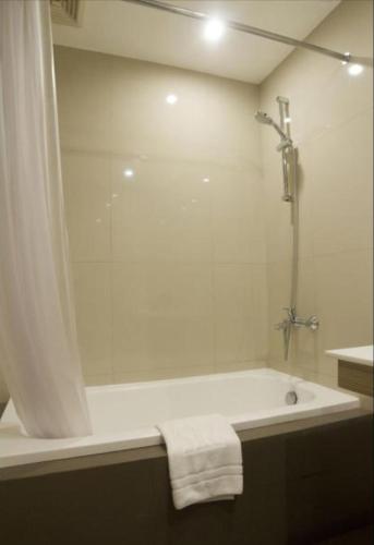 a bathroom with a shower and a bath tub at Rothman Hotel in Manila