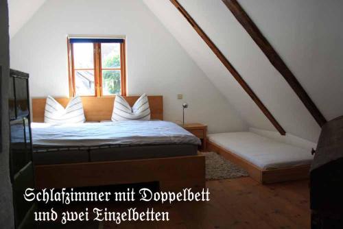 ein Schlafzimmer mit einem Bett und einem Fenster im Dachgeschoss in der Unterkunft Ferienhaus Mien Hüsing in Stralsund