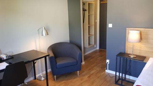 a room with a desk and a chair and a lamp at City Hotel in Kristinehamn