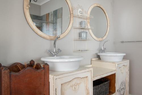 a bathroom with two sinks and a mirror at De Witte Huis in Bethlehem