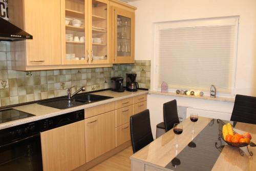 a kitchen with a sink and a table with chairs at Befeld Susanne in Neustadt in Holstein
