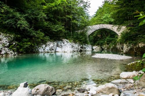 a bridge over a river with blue water at Apartma Fani-Kobarid in Podbela