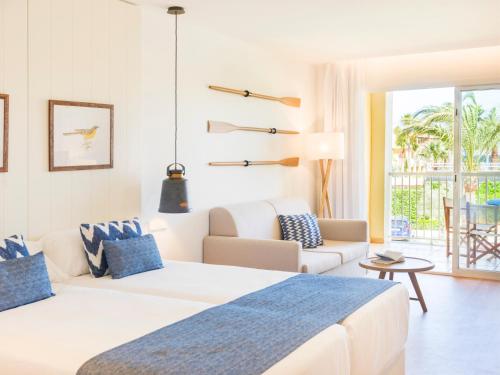 a bedroom with two beds and a living room at Club del Sol Aparthotel in Port de Pollensa