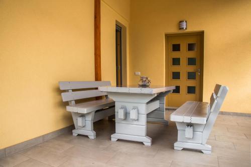 a table and bench in a room with a door at Apartma Fani-Kobarid in Podbela