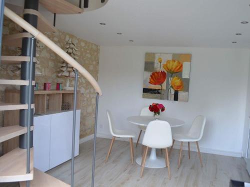 une salle à manger avec une table et des chaises blanches dans l'établissement Le Pigeonnier de Château Picon, à Eynesse