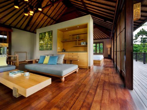 ein Wohnzimmer mit einem Bett und einem Tisch in der Unterkunft Hoshinoya Bali in Ubud