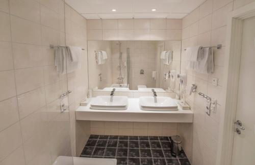 a bathroom with two sinks and a mirror at Best Western Leto Arena in Dal