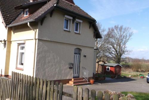 ein Haus mit einem Holzzaun davor in der Unterkunft Peper Ute in Neustadt in Holstein