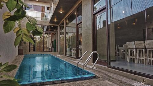 an indoor pool in a house with a large window at Hotel Sico in Negombo