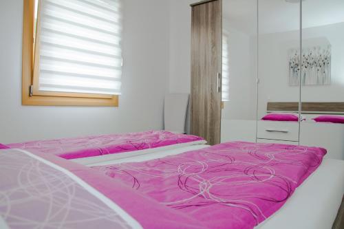 two beds in a room with purple sheets at Apartma Fani-Kobarid in Podbela
