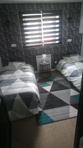 a bedroom with two beds and a checkered floor at Ilot Désille in Boulogne-sur-Mer