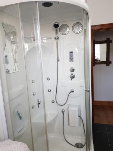 a shower with a glass door in a bathroom at Room @ Jasmine Cottage in Bathgate