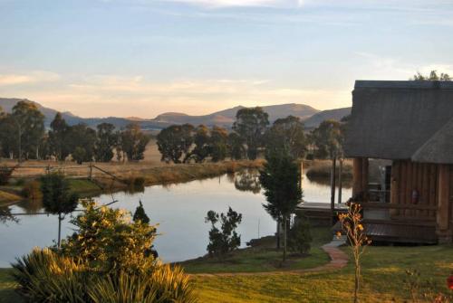 a house with a lake in front of it at Majuba Guest Lodge in Volksrust