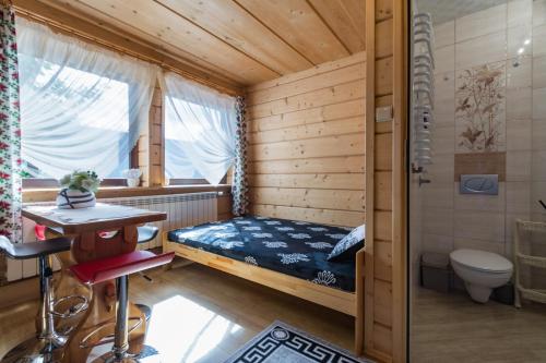niewielka sypialnia z łóżkiem i toaletą w obiekcie Mazurkowy Gościniec w Zakopanem