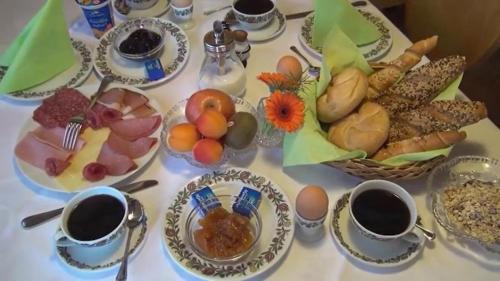 a table topped with plates of food and cups of coffee at Pension Sonnblick in Westendorf