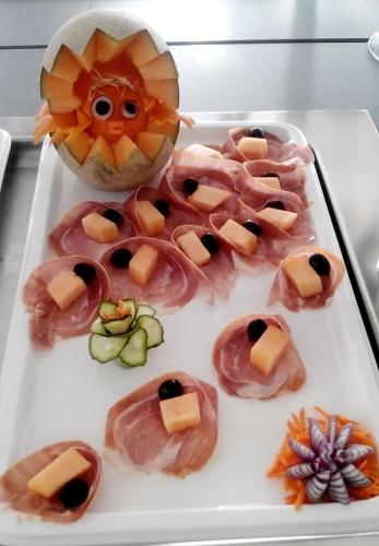 a tray of food with a face made out of food at Hotel IN in Biograd na Moru