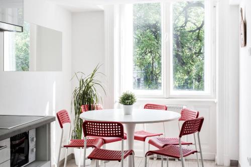 cocina con mesa blanca y sillas rojas en E-52 Apartment in center en Budapest