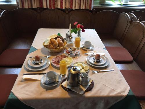 a table with a breakfast of food on it at Pension Kinzl mit E-Ladestation in Offenhausen