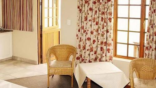 a living room with a table and chairs and a window at Windmill Farm in Bergville
