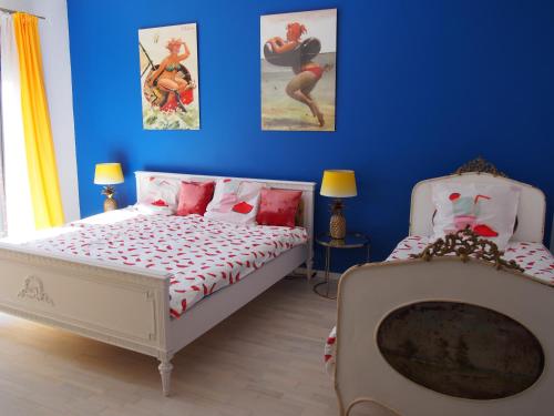 1 dormitorio azul con 1 cama y 2 cuadros en la pared en Apartament Wakacje i rowery gratis, en Ostróda