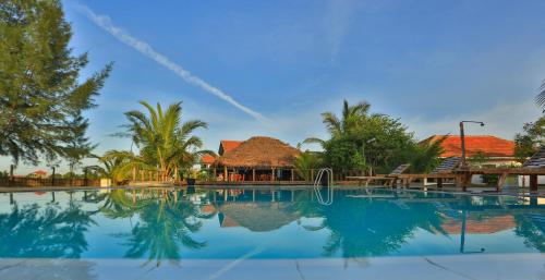 a view of a swimming pool with a resort at Paper Moon Kudils in Arugam Bay