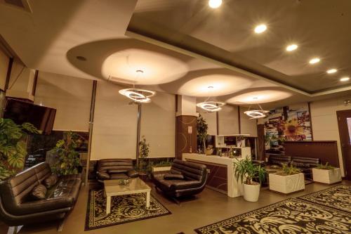 a large lobby with leather chairs and a table at Amazona Hotel in Pristina