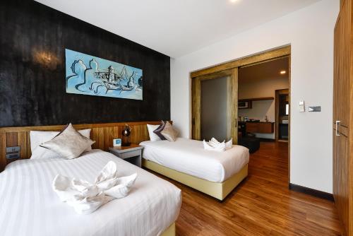 a hotel room with two beds with white sheets at Casa Bella Phuket in Chalong 