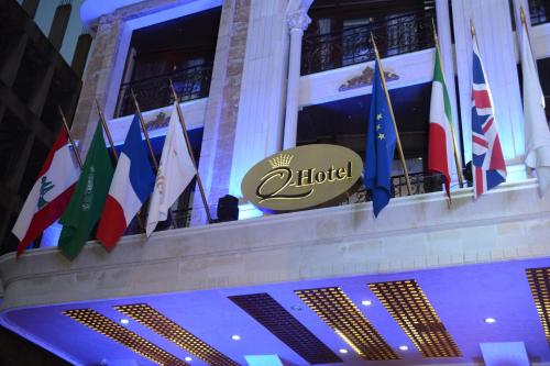 a bunch of flags on a building with a hotel sign at Q Hotel in Beirut